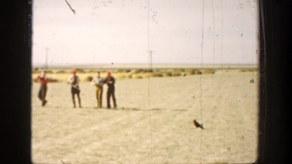 In 1936 California home-movie footage, four men stand in a sunlit field, several appearing to hold and aim long guns.