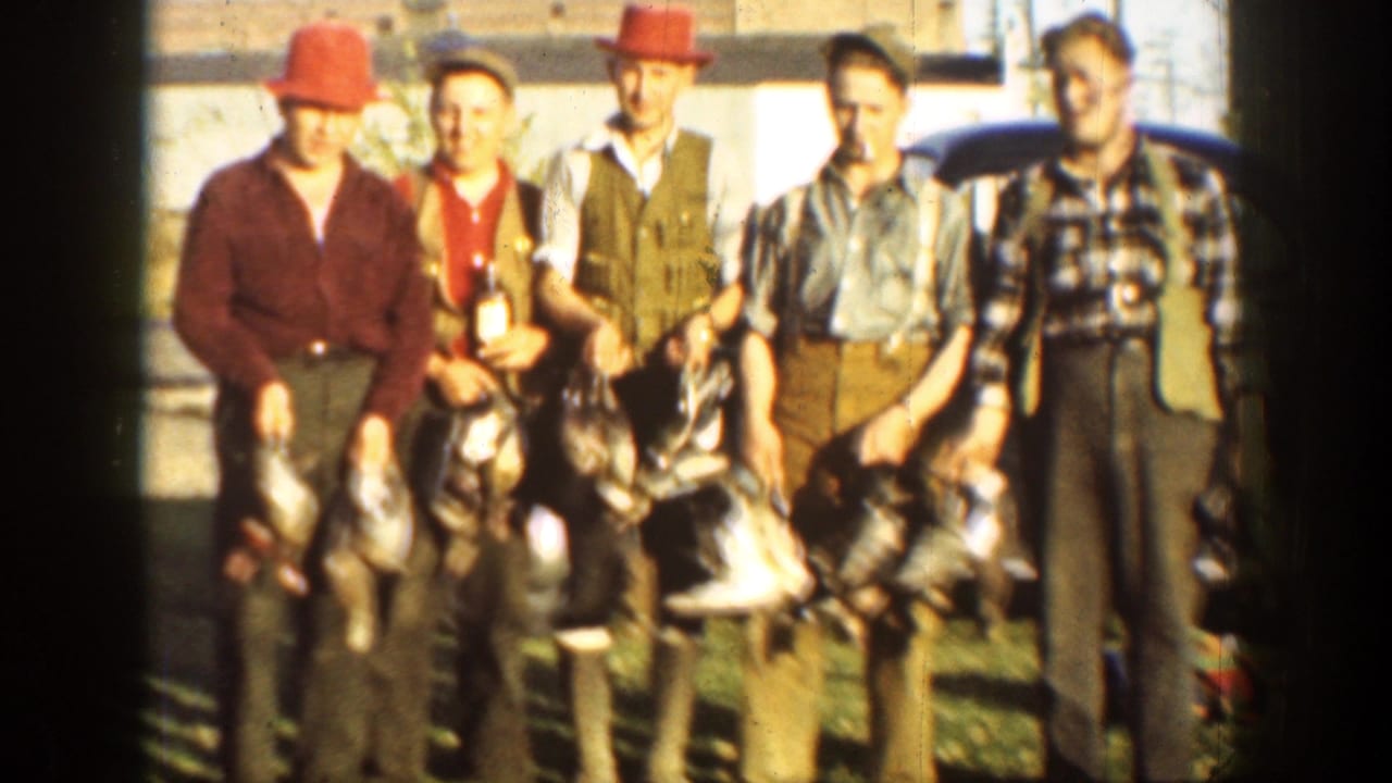 Five adult men in 1930s-style hunting clothes pose in California with ducks near a rounded car on grass.