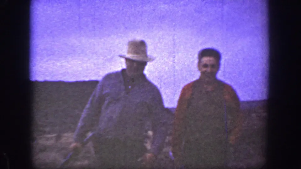 Near the end of the 1936 California home movie, two men fill the frame as they approach through dry terrain.