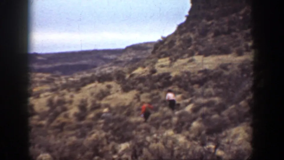 The hikers appear farther away in the arid California mountain landscape, with soft grain, faded color, and dark film borders.