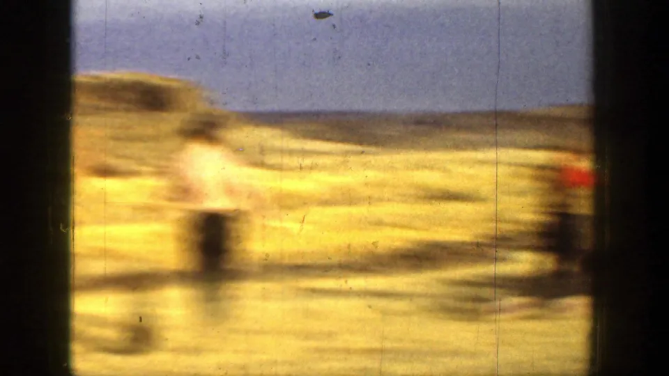 Motion-blurred 1936 California 8mm frame showing figures in a dry field during outdoor shooting activity.