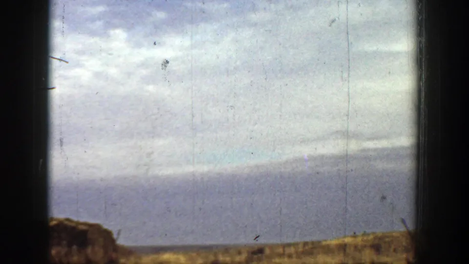 1936 California 8mm frame showing dry open ground, low hills, pale sky, and heavy dark gate edges with no clear figures centered.