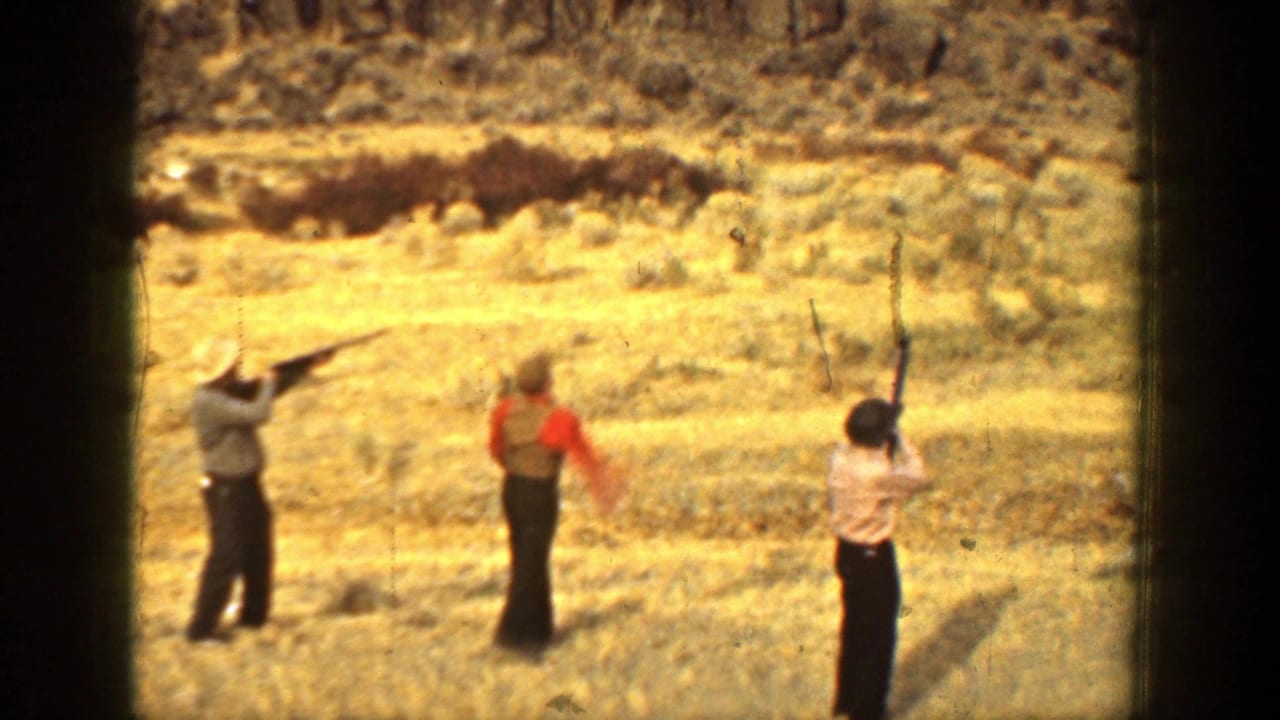 In 1936 California home-movie footage, three adult men stand in a dry field as two raise shotguns and another watches nearby.