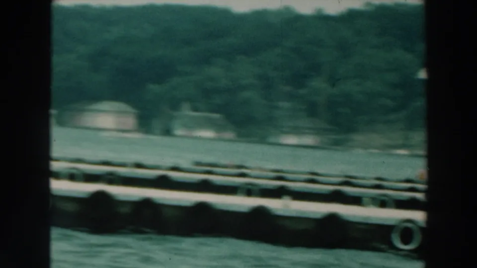 Lake Winnebago 8mm frame showing floating docks, water, and a soft, distant shoreline after the sailboat has moved out of view.