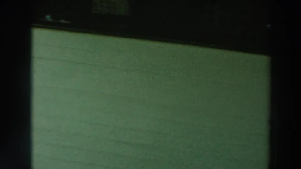Close 1964 home-movie view of a pale green dockside or boathouse surface, with dark framing above and visible film grain.