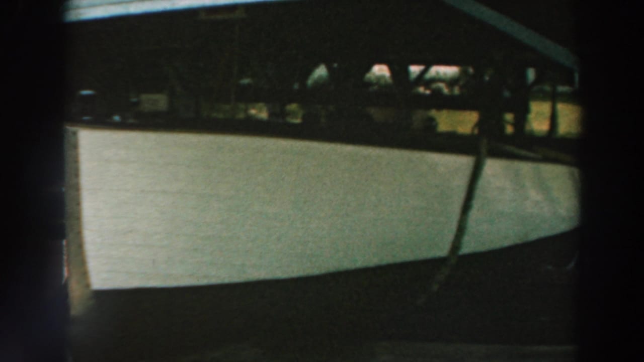 White boat under a covered dock with dark frame edges.