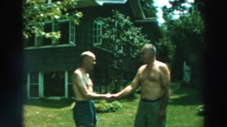 The two older men face one another and shake hands in the 1964 Lake Winnebago backyard scene.