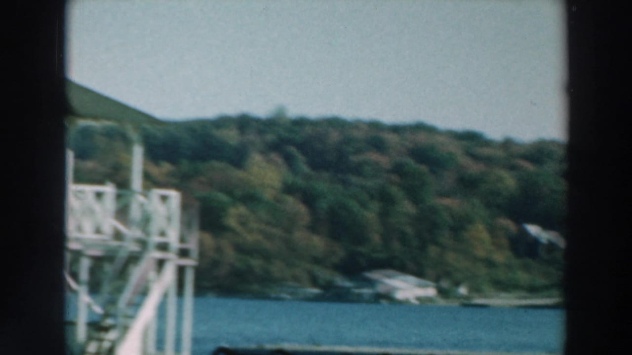 Lake Winnebago shoreline passes behind a white tower-like dock structure, with trees and low hills in the background.