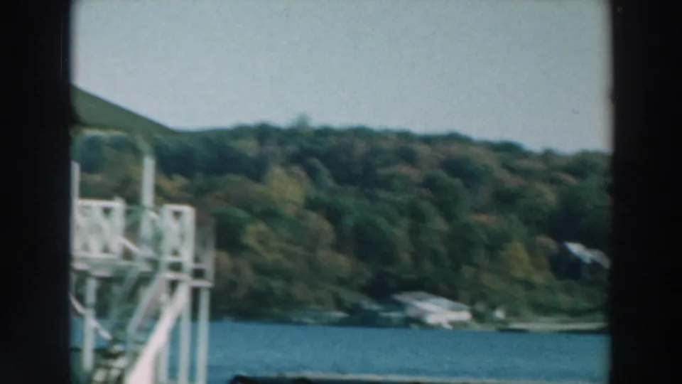 Lake Winnebago shoreline passes behind a white tower-like dock structure, with trees and low hills in the background.