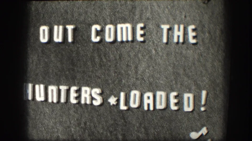 1958 Kansas 8mm frame showing the hunting title card, with white lettering, dark background, grain, and slight film distortion.