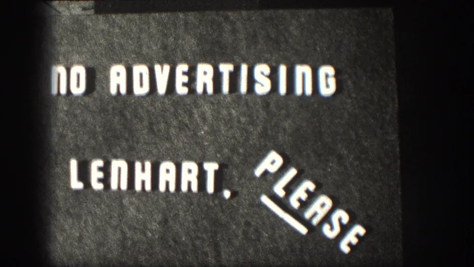 Final visible frame of the spliced 8mm title card reading NO ADVERTISING LENHART, PLEASE on a dark textured background.