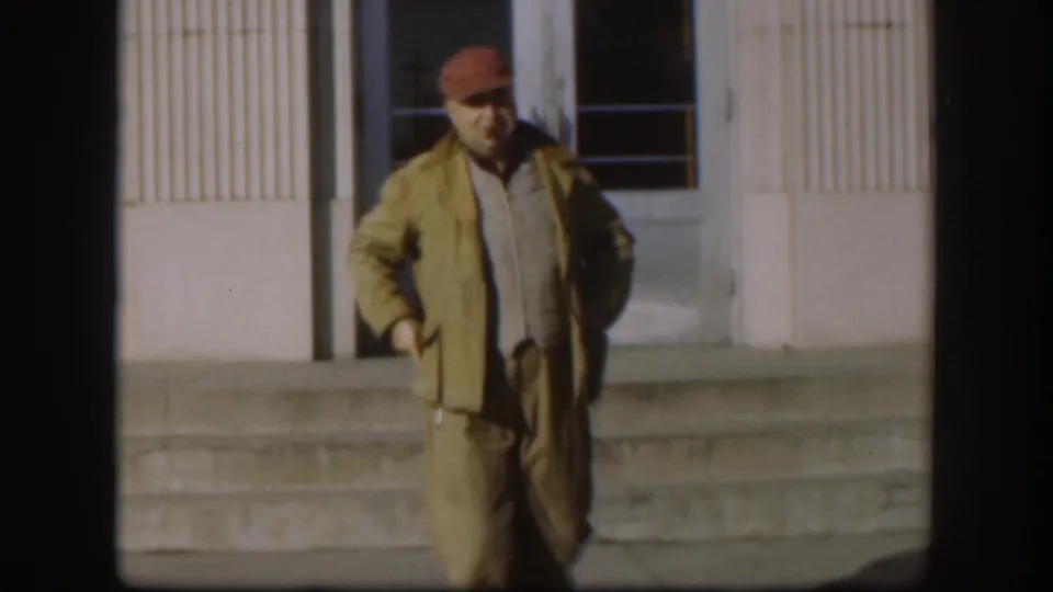 The Kansas 1958 frame shows the man closer to the camera, standing before the building facade with one hand near his pocket.