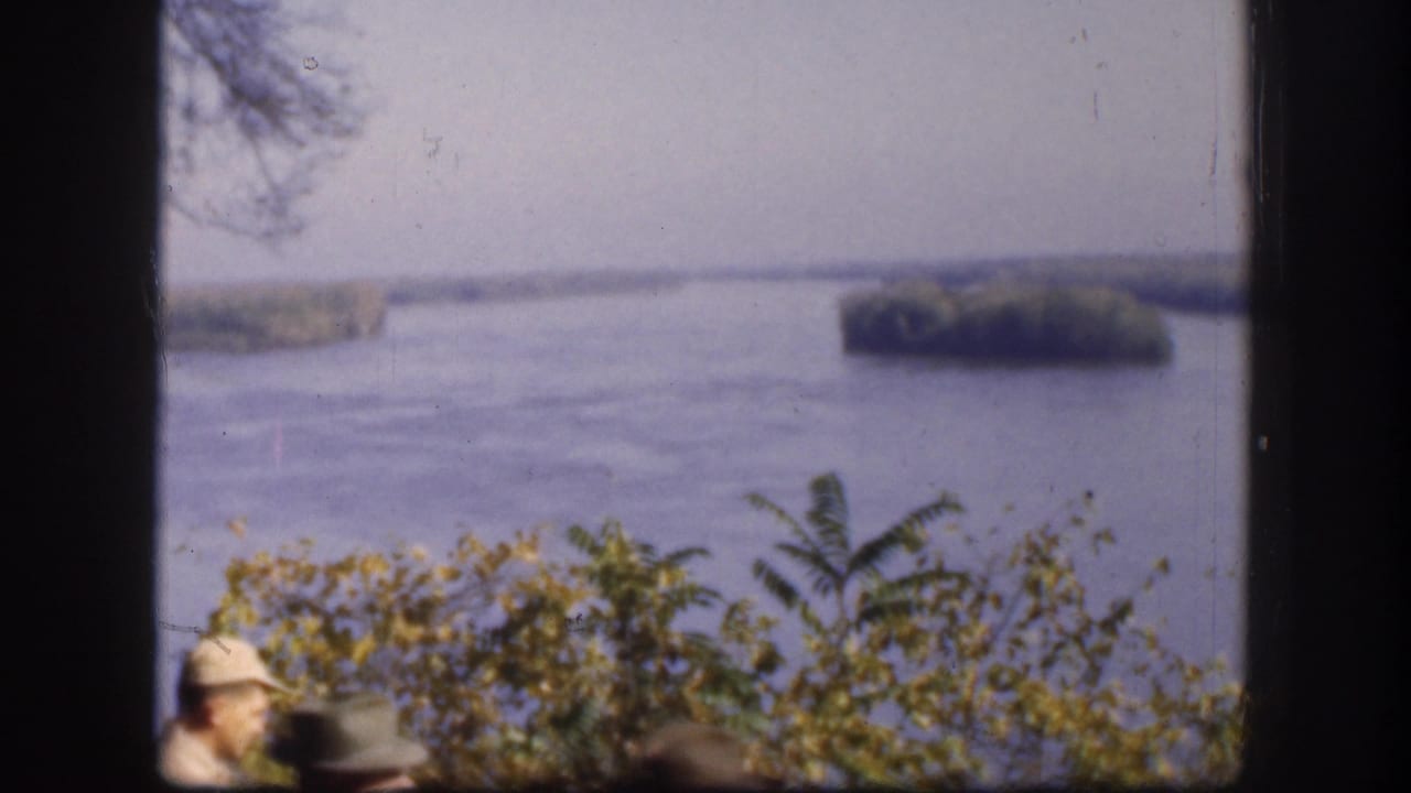 1958 Kansas 8mm frame with a scenic water view and a partially visible visitor wearing a light hat near the bottom edge.