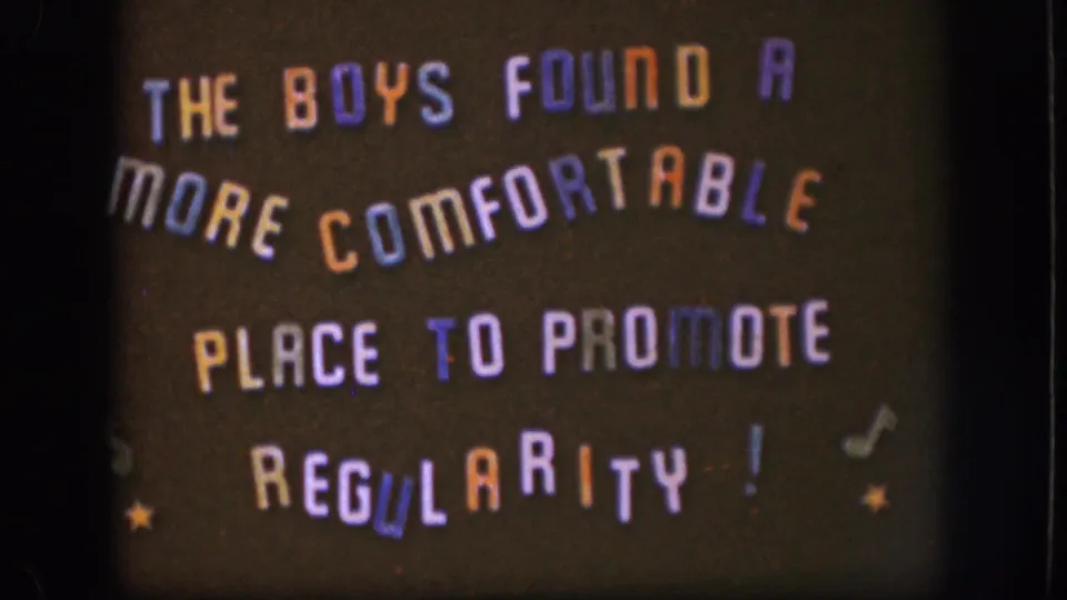 1958 8mm title card with playful multicolored lettering about the boys finding a more comfortable place to promote regularity.