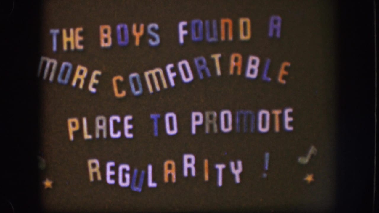 1958 Kansas 8mm frame showing a handmade humorous sign with arched colorful lettering, stars, and musical notes.