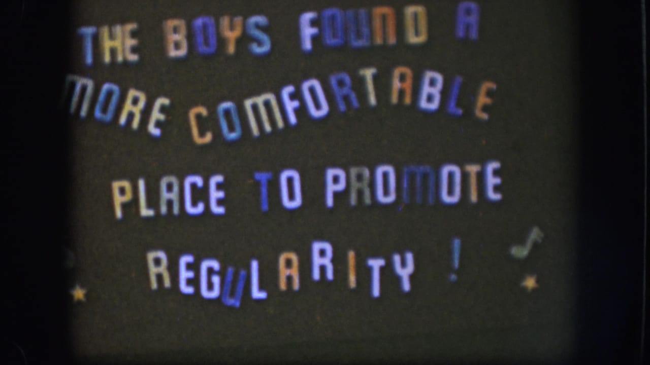 1958 Kansas 8mm frame showing a dark handmade title card with multicolored text, small stars, and musical-note marks.