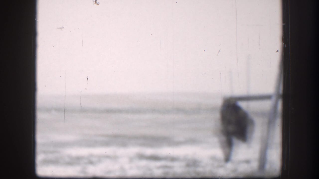 1958 Kansas winter view through a window, with snow, pale sky, and an indistinct dark shape near the right side of the frame.