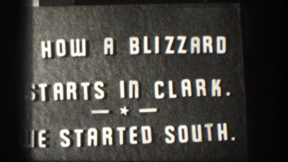 1958 Kansas 8mm title card with bold white lettering introducing how a blizzard starts in Clark and a trip south.