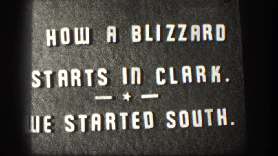 Kansas 1958 home-movie title card with centered white text about a blizzard starting in Clark and starting south.