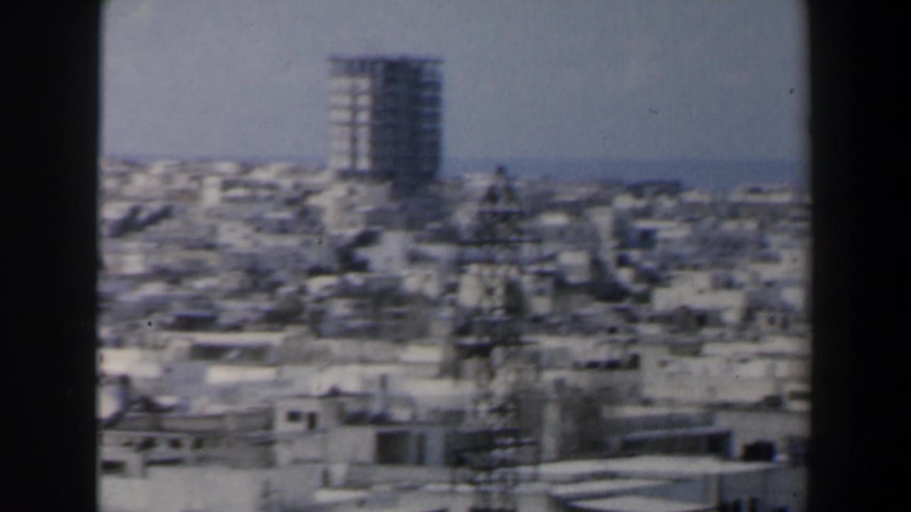 Urban rooftops with a tall block and rooftop utility structure.