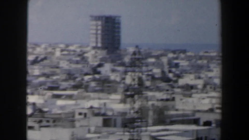 1960 Israel city panorama showing crowded flat-roofed buildings, a tall tower block, and rooftop structures.