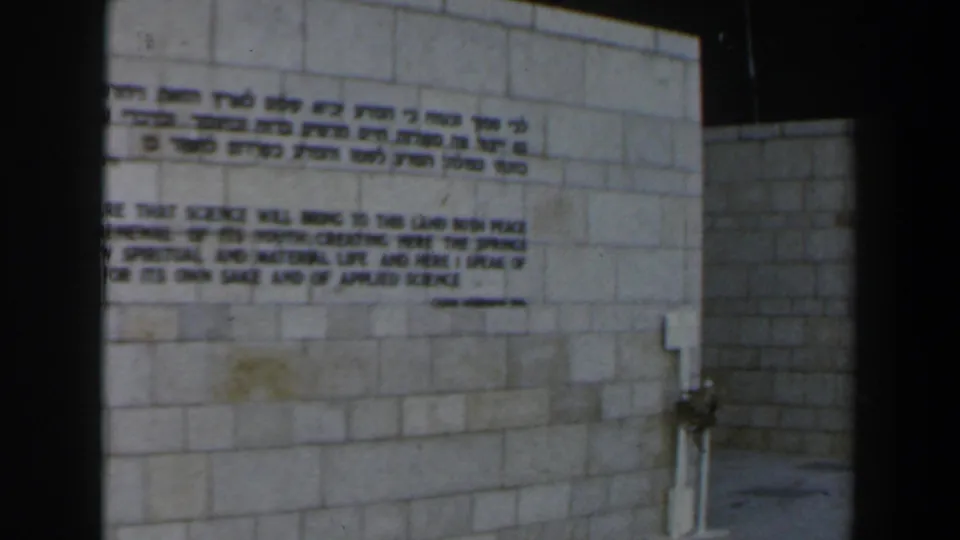 Visitor-shot 8mm frame of the inscription wall, slightly shifted and cropped by handheld framing.