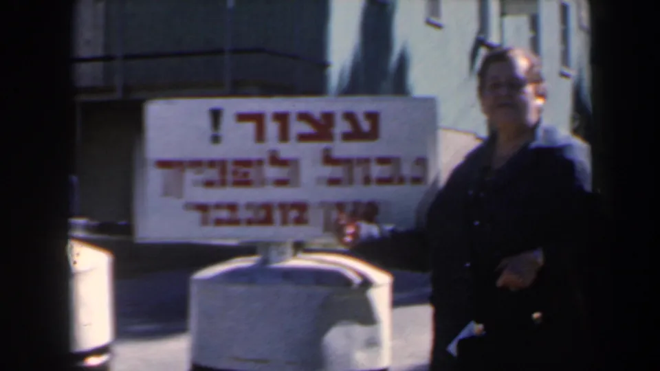 The final 1960 Israel frame shows the woman at right beside the bilingual frontier sign and concrete barrier.