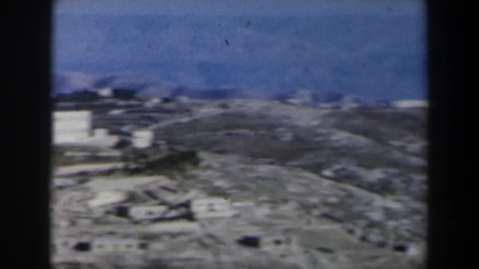 1960 Israel frame with white buildings on dry terrain, partially obscured by a dark vertical film edge.