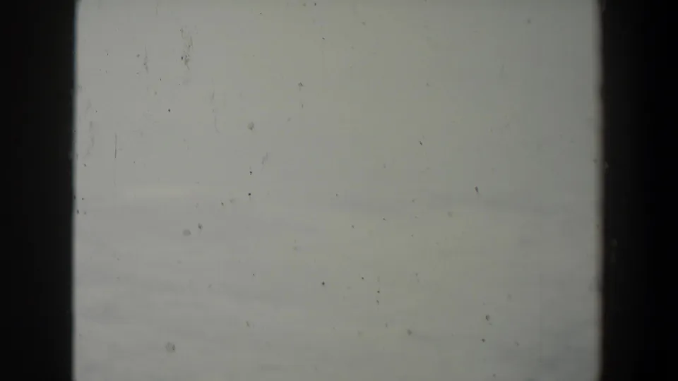 Pale blank leader or overexposed film at the end of the 1960 8mm clip, with dust and gate edges visible.
