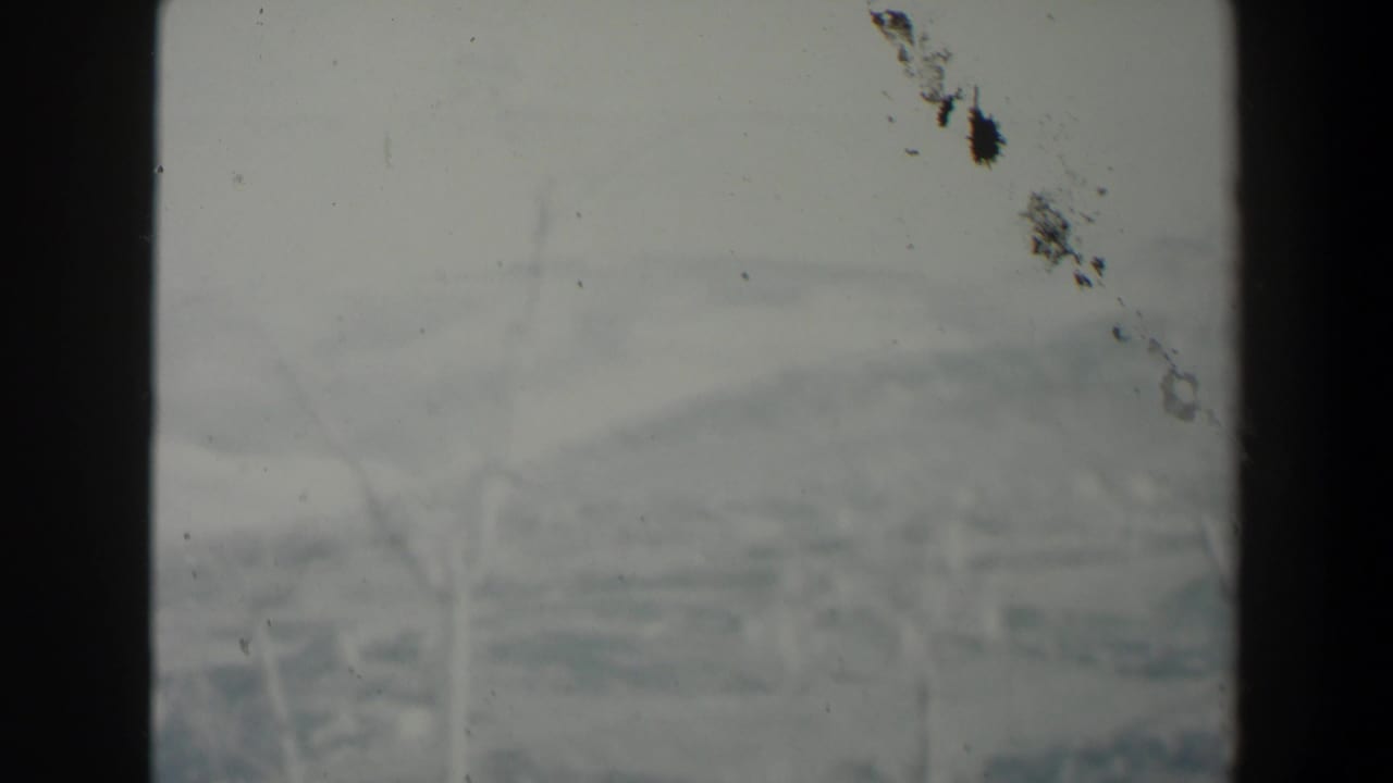 1960 Israel 8mm view with distant hazy terrain and faint branches divided by a dark window-like vertical bar.