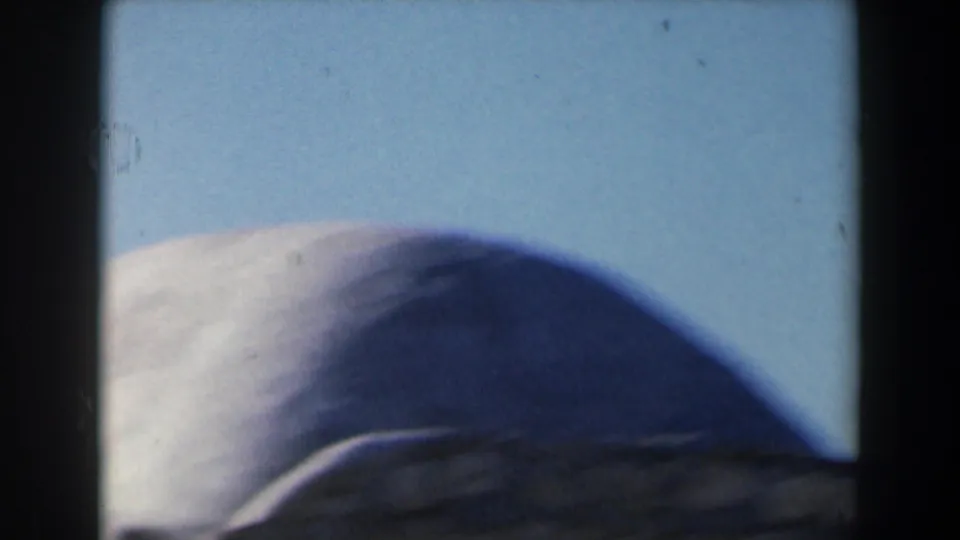 1960 Israel 8mm frame showing a rounded pale stone dome or rooftop form beneath a clear blue sky.
