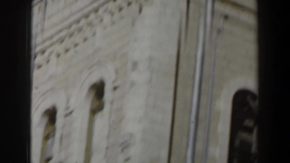 Soft 8mm view of a white stone building facade in Israel, with arched openings and architectural trim visible.