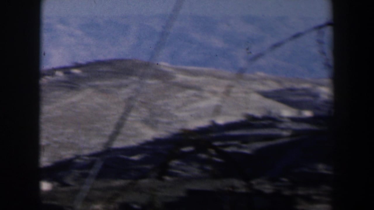 Desert hills under blue sky seen through dark vertical frame edges.