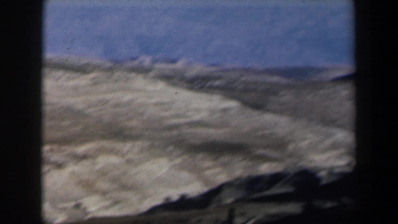 Sunlit desert mountains with a dark foreground frame at the center and side.