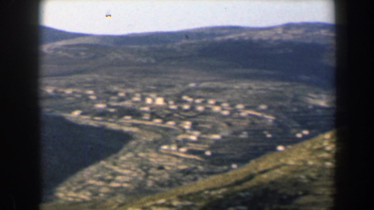 1960 Israel 8mm view of a small white hillside village set among rugged, dry mountain slopes.