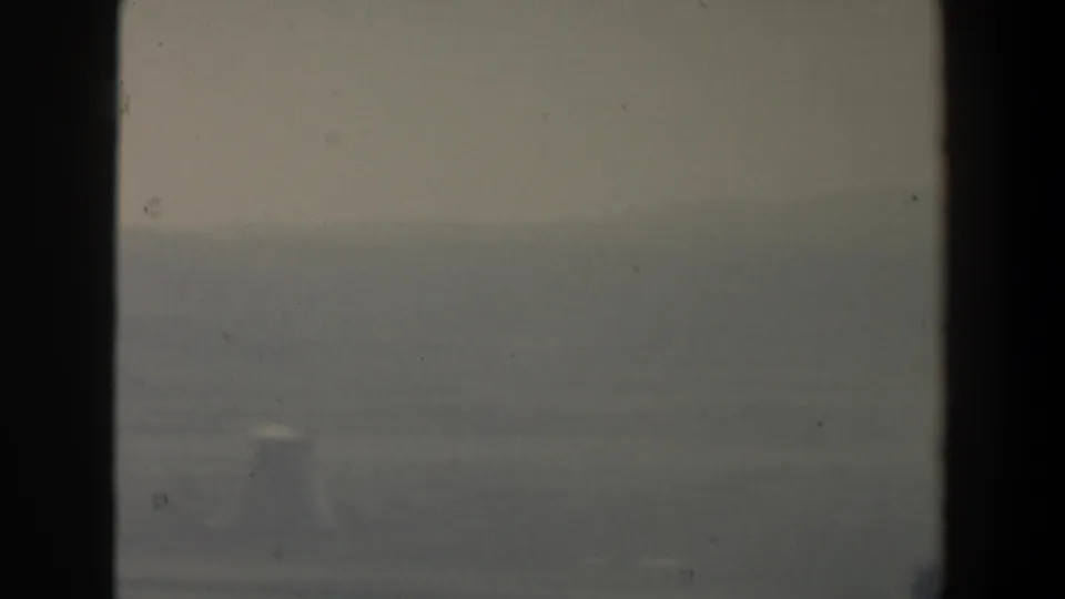 1960 8mm view in Israel showing distant hazy hills and terrain framed by dark window or vehicle supports.