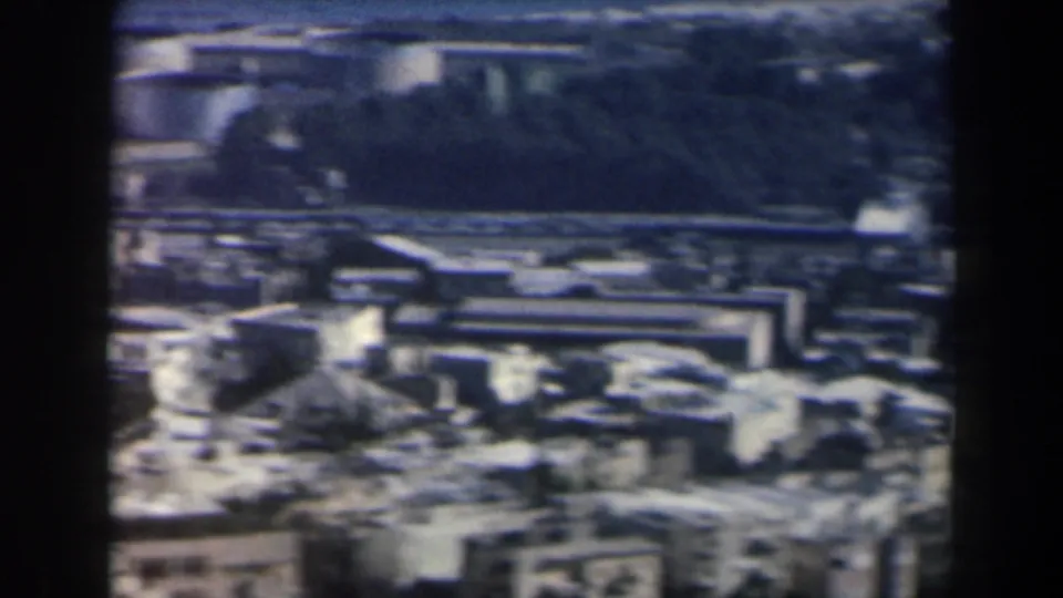 1960 Israel 8mm aerial frame with buildings, roads, fields, and a darker rectangular planted or paved area.