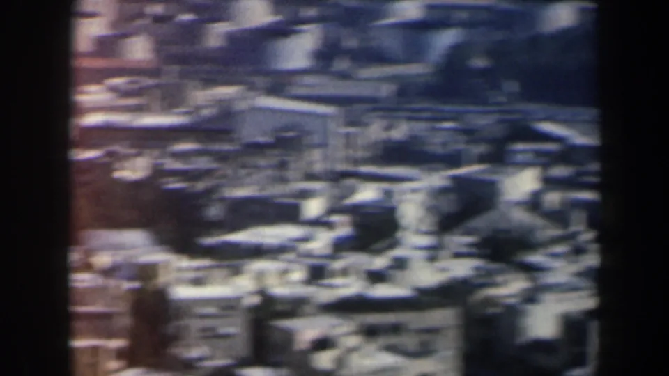1960 Israel home-movie frame showing a soft, elevated view over dense low-rise buildings and rooftops.