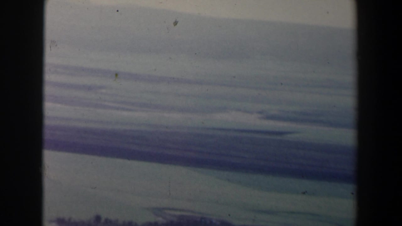 1960 Israel 8mm view of horizontal storm-cloud layers with a dark lower edge and visible contact-sheet divider.