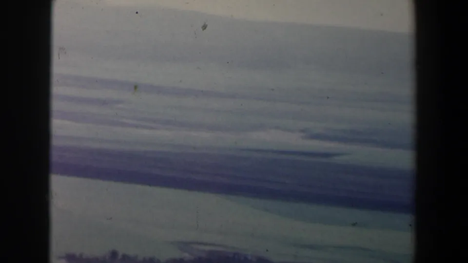1960 Israel 8mm view of horizontal storm-cloud layers with a dark lower edge and visible contact-sheet divider.