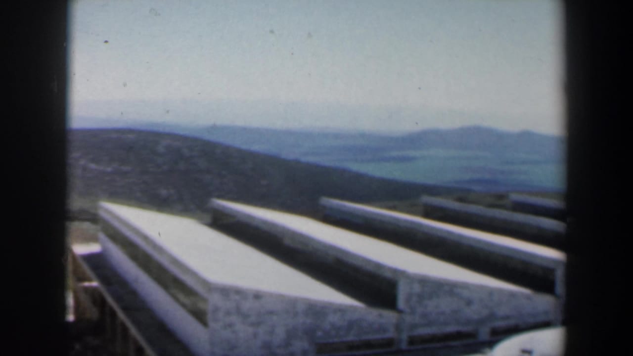 Concrete stair-like structure seen across a hillside with hazy hills beyond.