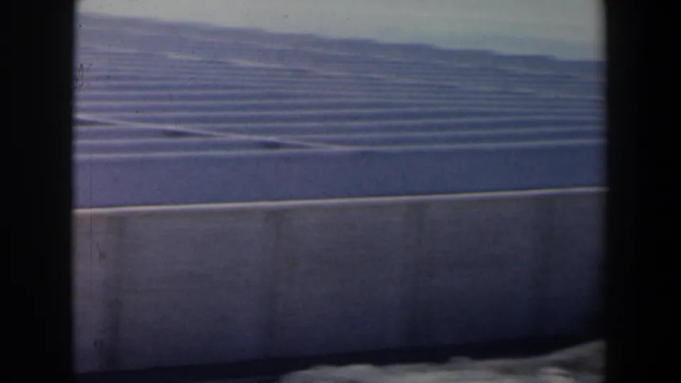 1960 Israel detail of ribbed roof lines and a concrete wall, framed by the dark edge of the 8mm shot.