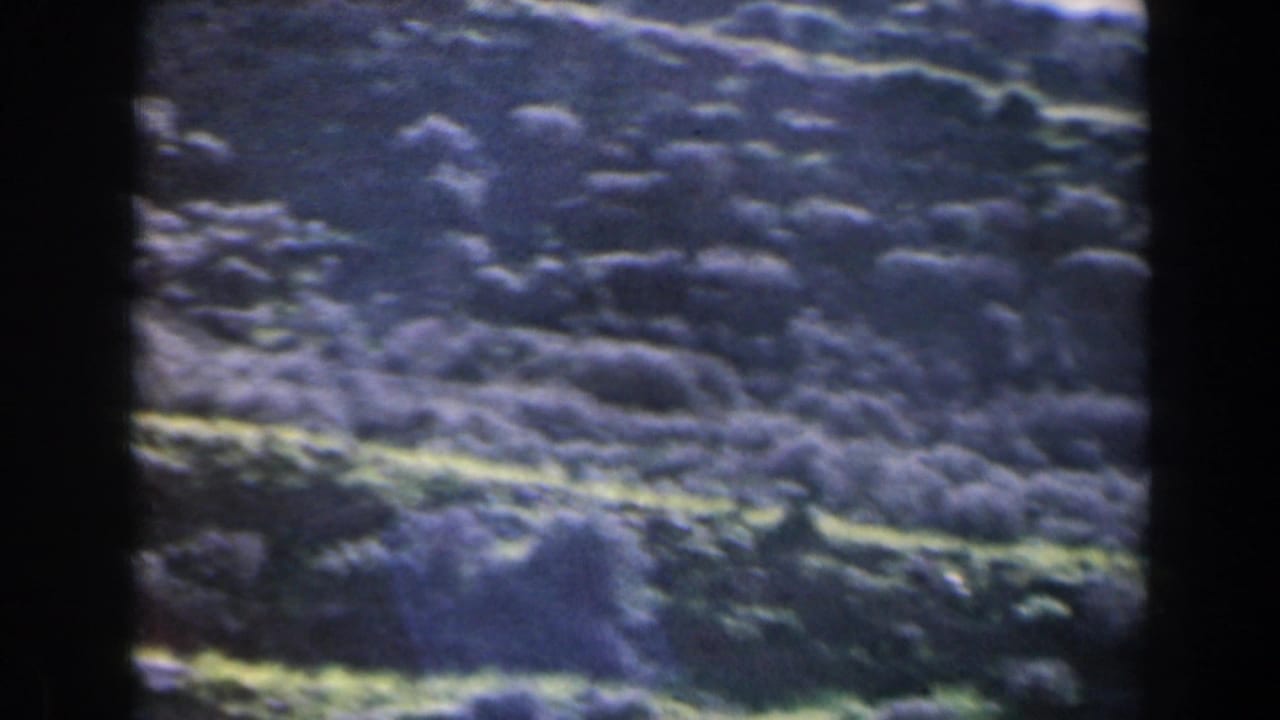Clouded or textured landscape seen through dark 8mm frame edges.