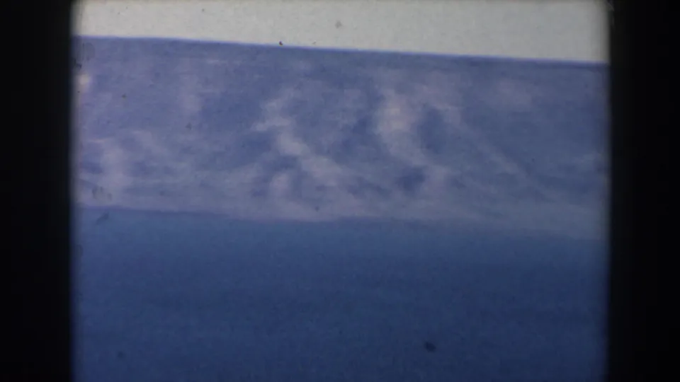 1960 Israel 8mm frame showing open blue sea, a hazy horizon, and dark borders from the filmed viewpoint.