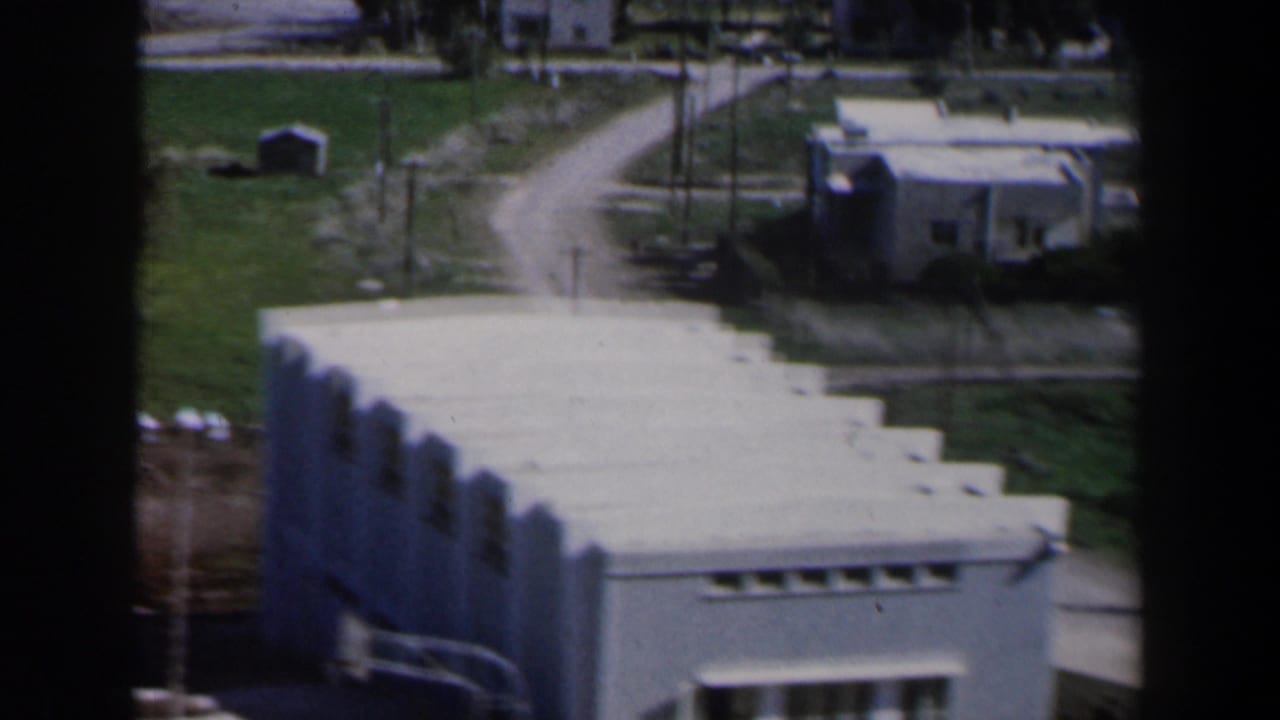 White stepped building beside fields and dirt roads.