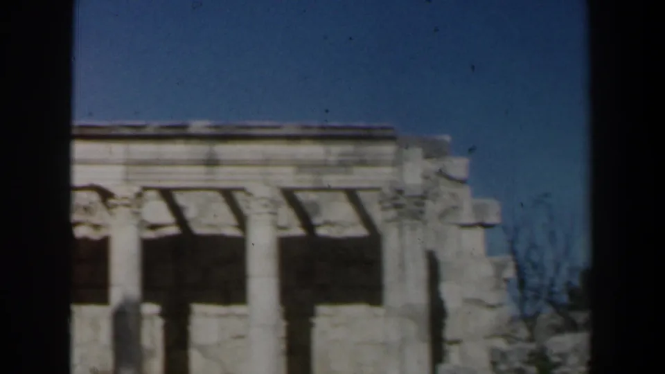 1960s Israel frame showing upright stone columns, partial overhead structure, and weathered masonry under blue sky.