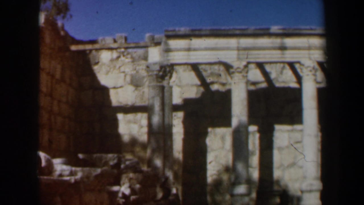 1960 8mm footage in Israel showing a stone passage beside weathered walls and a columned ruin facade.