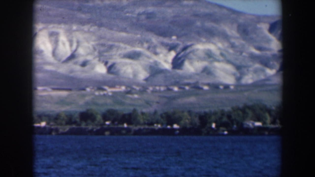 Distant shoreline beneath pale ridged mountains across a lake.