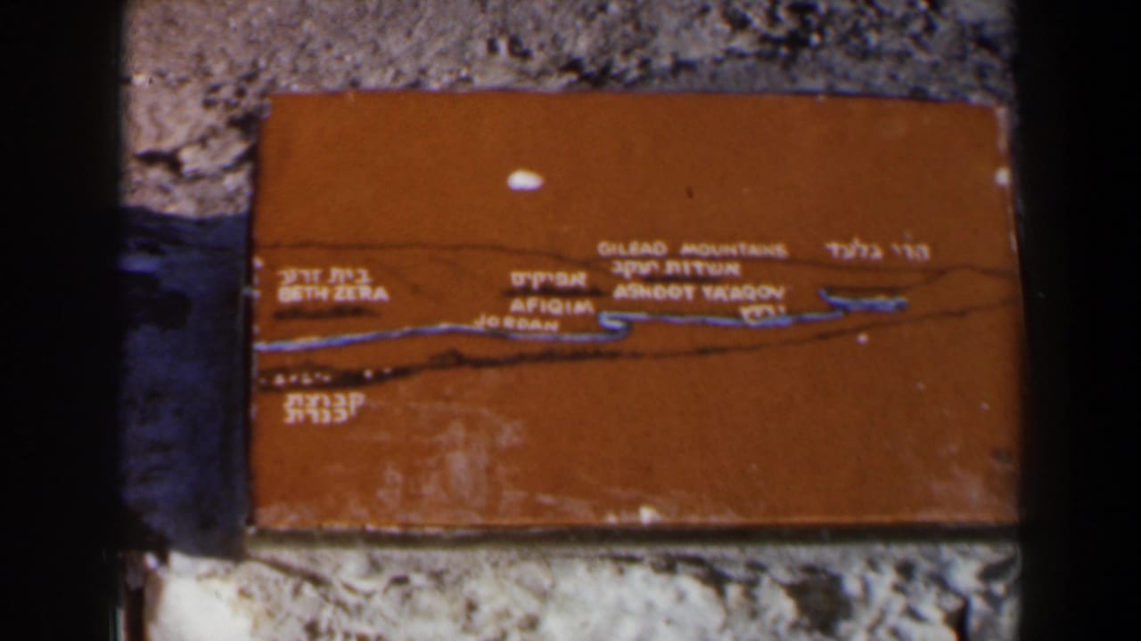 Close view of the same orange map plaque with bilingual lettering.
