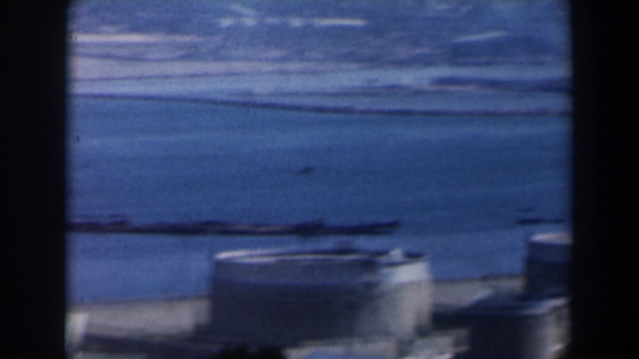 Hazy harbor water and shoreline seen through dark vertical frame edges.